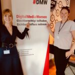 Mareike Oehrl (stellvertretende Quartiersleiterin, #DMW Rhein-Neckar) und Johannah Illgner (Quartiersleiterin, #DMW Rhein-Neckar) vor einem Rollup mit Logo der Digital Media Women